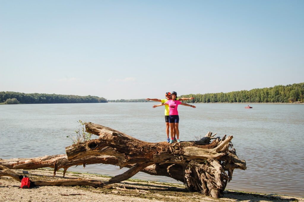 Mädchen spielt auf Baumstamm am Ufer der Donau, Österreich