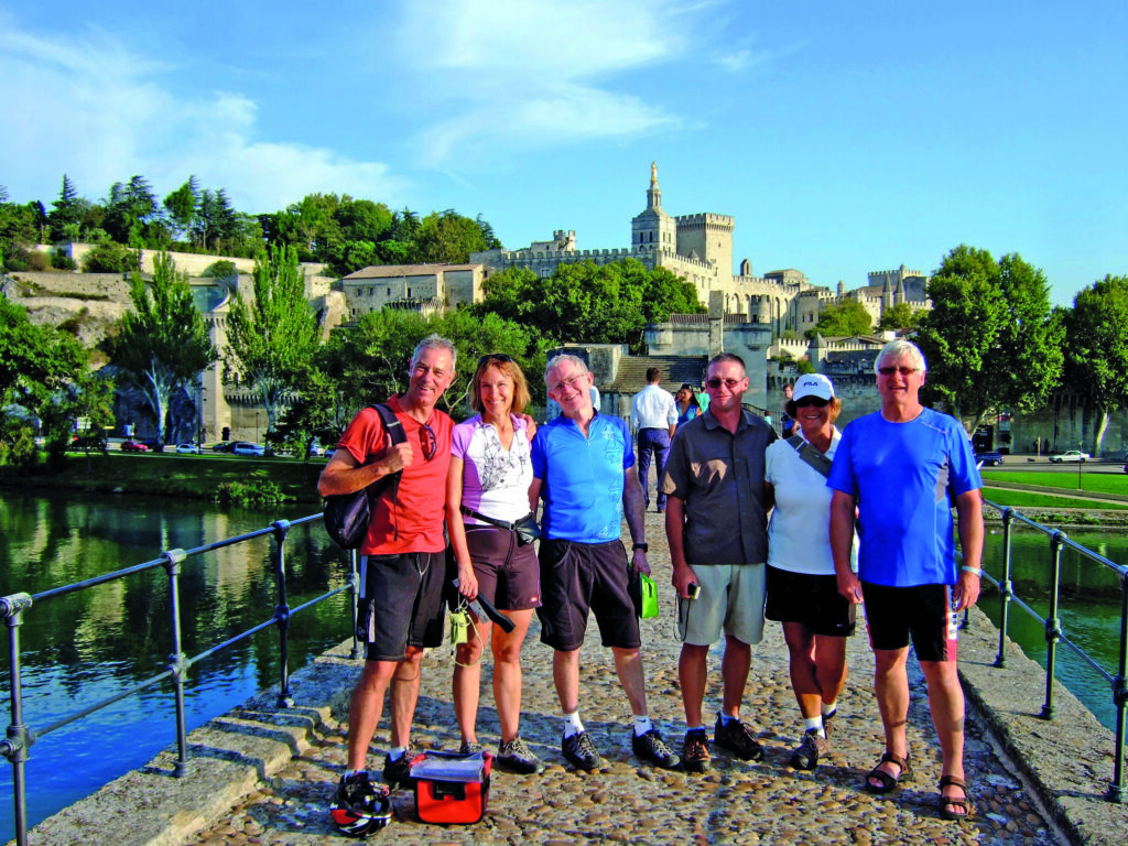 Gruppe von Radfahrern posiert auf der Brücke von Avignon, Provence, Frankreich.
